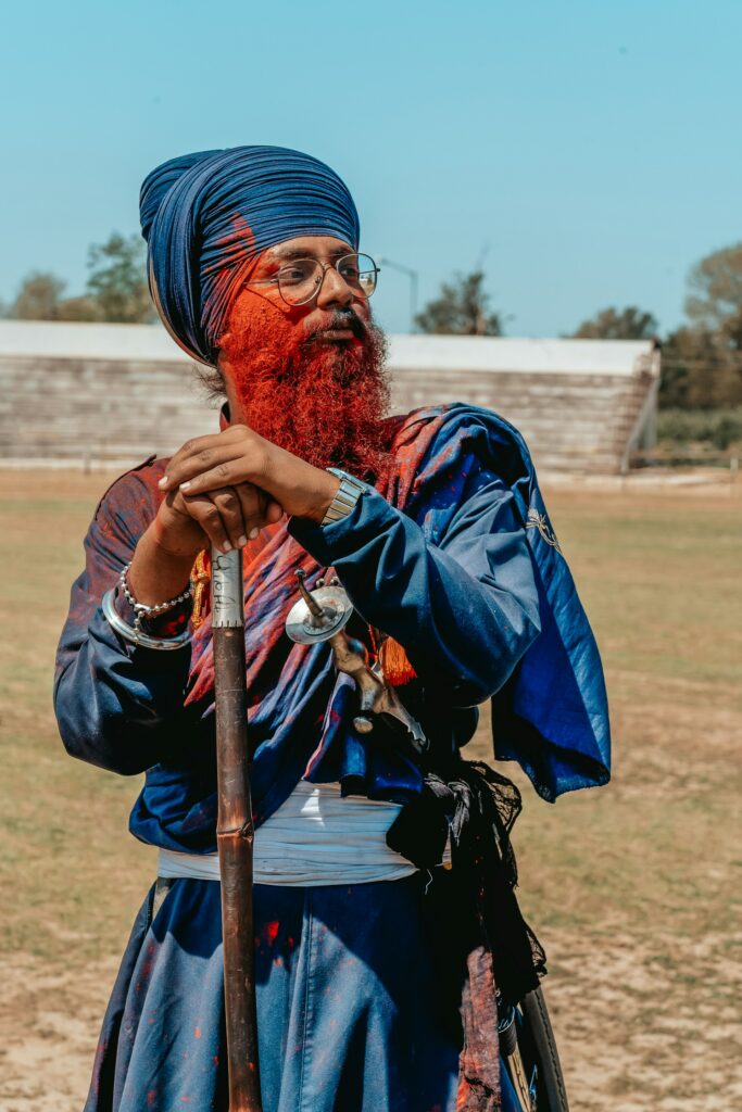 Nihang Sikh with orange-dyed beard and blue robe at Hola Mohalla festival in Punjab