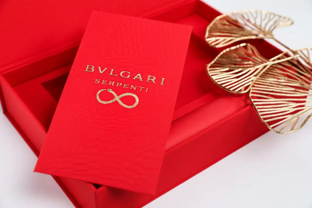 Bvlgari Serpenti red packaging with gold embossed infinity symbol and snake-skin texture.
