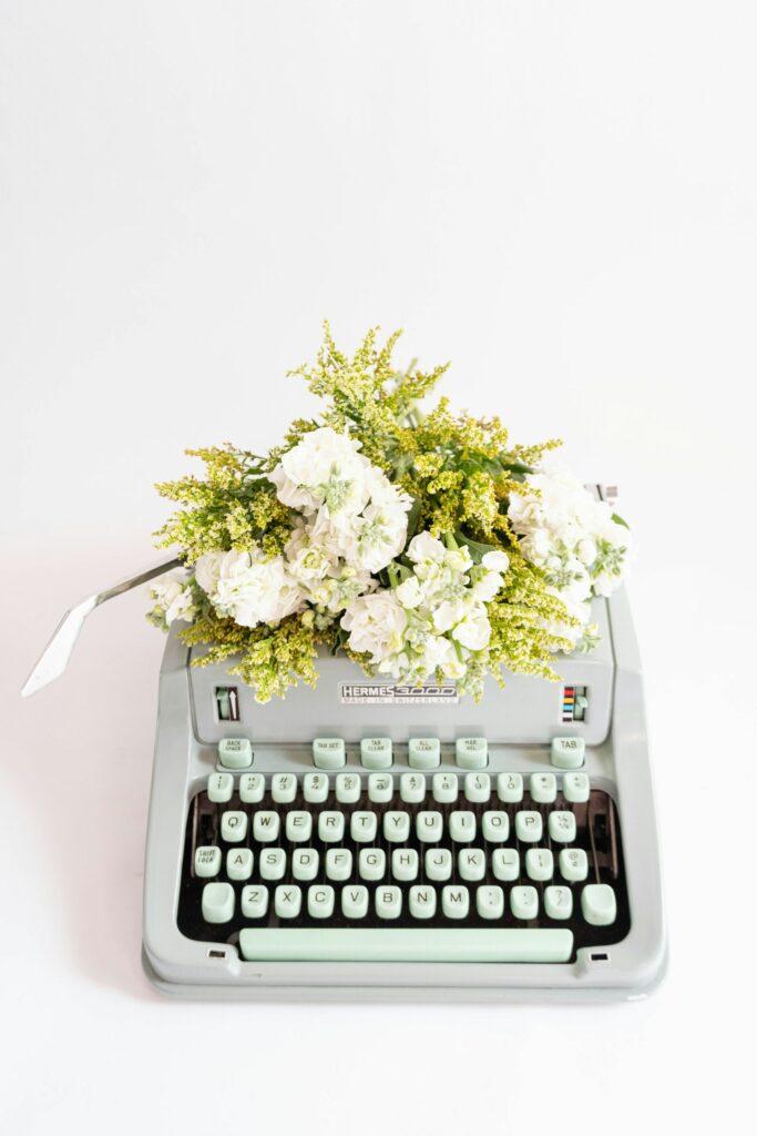 typewriter with white flowers placed on top