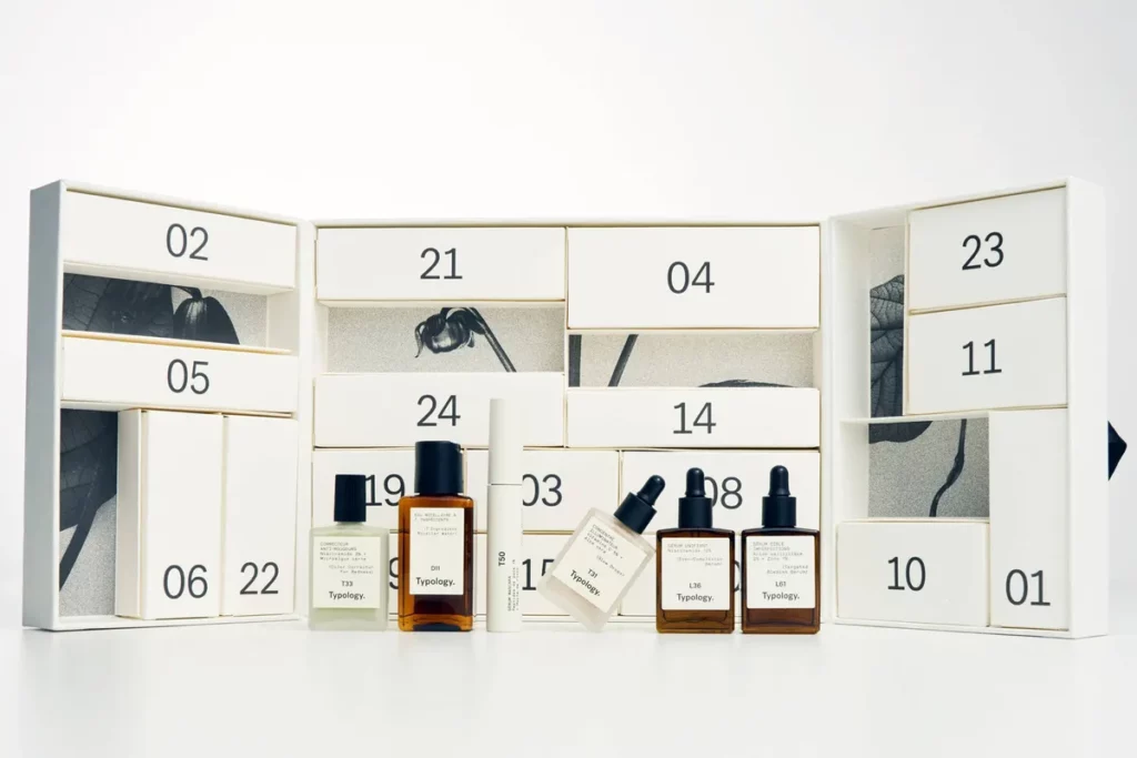Typology minimalist advent calendar with numbered drawers and skincare bottles, reflecting calm, typography-led Christmas 2025 graphic codes.