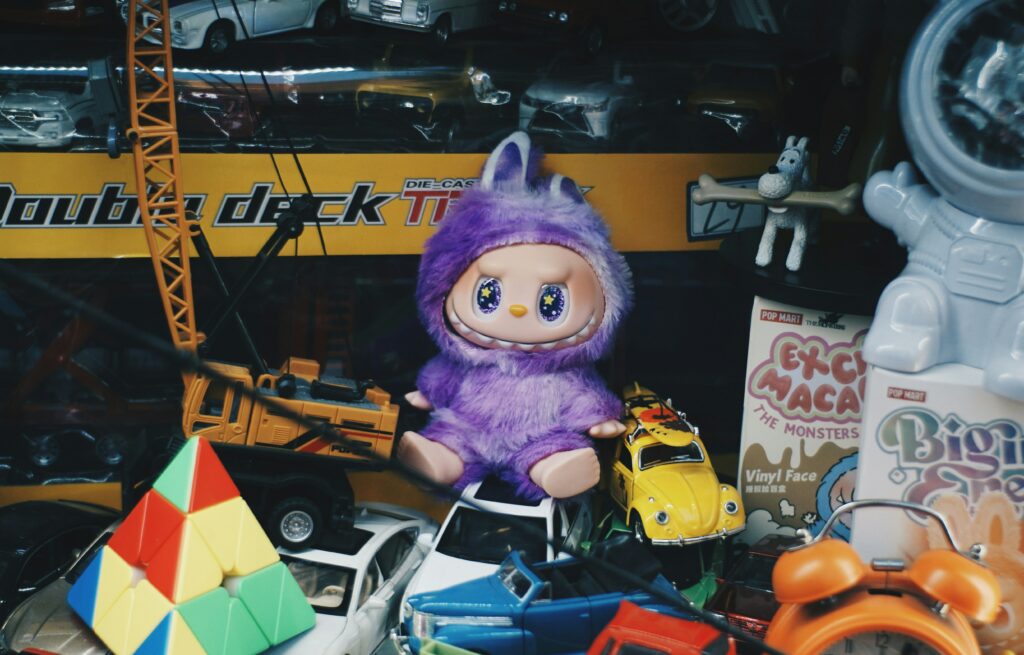 Plush toy surrounded by collectibles and toy cars, illustrating regressive nostalgia and kidult culture among adults