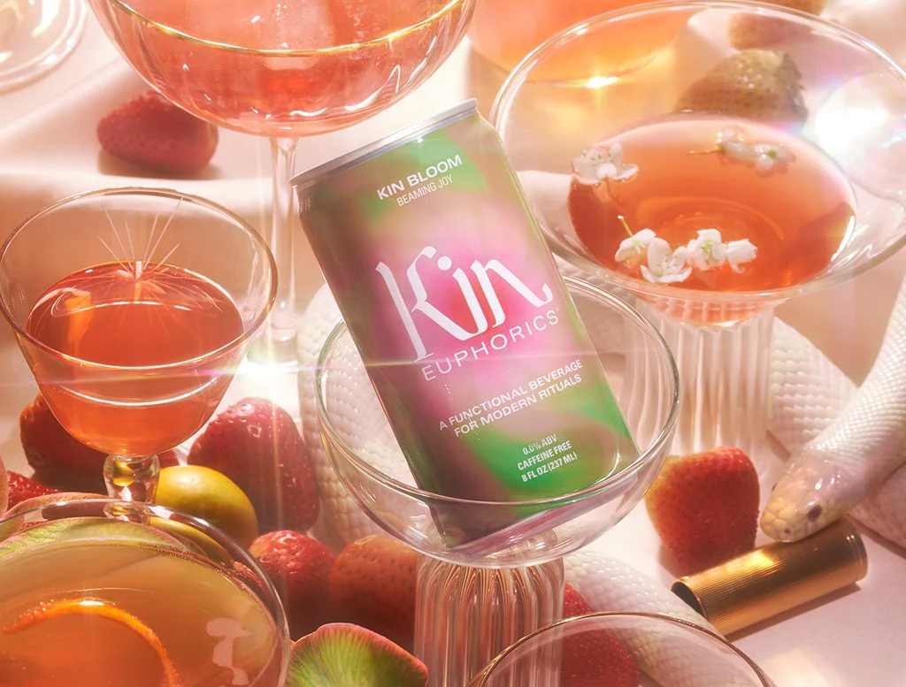 Kin Euphorics functional beverage surrounded by fruit and cocktails, illustrating drinks designed for mood and wellbeing.