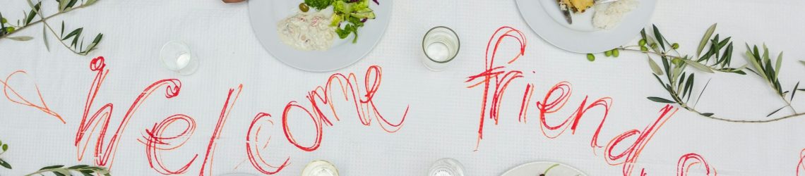 People from different cultural backgrounds sharing a meal together, representing multicultural marketing and cultural connection.